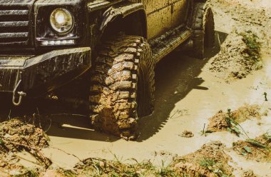 Off-road aracı dağda gider. Yarış yoldan çamur ve su sıçrama içinde. Alt görünümü büyük offroad araba tekerlek üzerinde ülke road ve dağlar zemin için