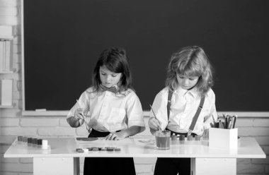 Çocukların yaratıcı gelişimi. Resim okulu öğrencileri resim ödevi yapıyor. Çocuklar ilkokulda resim çiziyor.