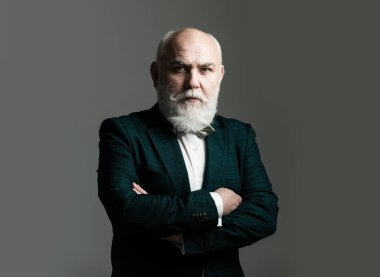 Kolları bağlı, Takım Elbiseli Adam. Sakallı, orta yaşlı, ciddi bir yüz ifadesi olan, yakın plan bir kafa ve omuz portresi olan adam.
