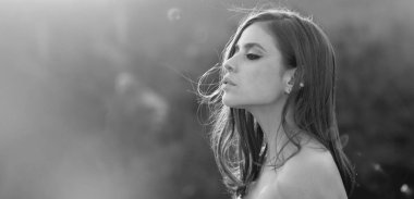 Spring woman on sunlight romantic portrait, sensual sunny face. Banner for website header. Young woman outdoor enjoying the sunlight. Spring romantic casual woman portrait