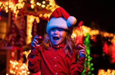 Çocuklar kış tatili ve kutlama. Çocuk dışarıda noel evinde. Bir evin önündeki Noel süslemesi