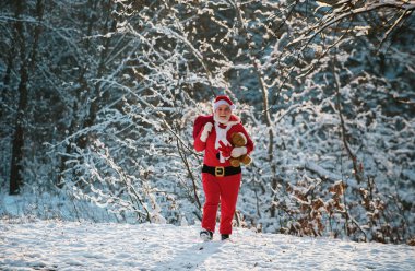 Noel baba hediyeler dağıtır. Noel giysileri içinde Noel Baba, karlı kış dağında