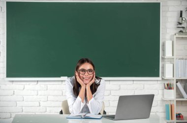 Üniversite ya da lisede çekici bir genç kızın portresi. Serbest çalışan bir kadın mı yoksa dizüstü bilgisayarlı gözlüklü bir öğrenci mi?