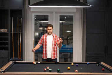 Bilardo oynayan adam. Bilardo salonunda topa vurmaya çalışan bir adam. Rus bilardosu. Bilardo oyuncusu. Siyah bilardo kulübünde bilardo oynayan genç bir profesyonel.