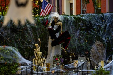 Cadılar Bayramı süslemeleri. Amerikan evi için Cadılar Bayramı balkabağı ve iskeleti. Bir Amerikan evinin ön bahçesinde dekore edilmiş korkunç bir şey. Şeker mi şaka mı? Amerika 'da Cadılar Bayramı. Amerika 'da Cadılar Bayramı
