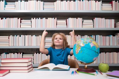 Bir fikrim var. Okul ve öğrenciler sınıfta. Eğitimli çocuklar. Okul sınıfındaki çocuk öğrenci. Okuma ve öğrenme konsepti. Okul çocuğu kütüphanede, okul malzemelerinin yanında. Coğrafya öğrenen çocuk