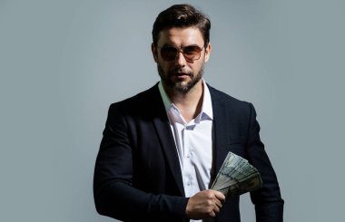 Dolar banknotları olan bir adam. Bir sürü 100 dolarlık banknot tutan bir iş adamı. Kolay para. Kara para. Ödeme günü ve ödeme konsepti. Kâr ve zenginlik. Para kazan. İş adamı başarılı anlaşma
