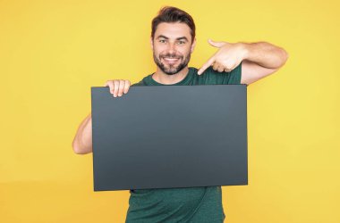 Adamın elinde fotokopi alanı var. Kopya uzay ürünü için pankart hazır. Kopyalama uzayı metnini imzala. Stüdyonun arka planında boş işaret panosu gösteren bir adam var. Boş kopya alanı boş tahtası