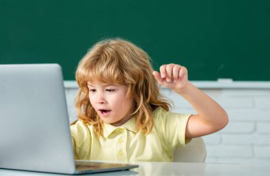 Okul çocuğu sınıfta dijital bilgisayar kullanıyor. İlkokul öğrenim programının komik öğrencisinin portresi. Çevrimiçi öğrenme teknolojisi, sanal eğitim webinar