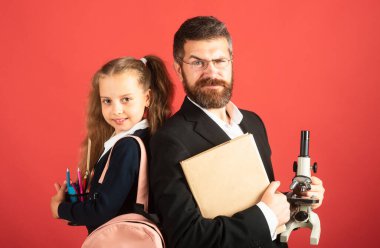 Red Stüdyo 'da öğretmen olan ilkokul öğrencisi, izole edilmiş. Komik liseli kız portresi ve okul malzemeleriyle özel öğretmen. Mutlu öğretmen ve öğrenci kız kırmızıda.