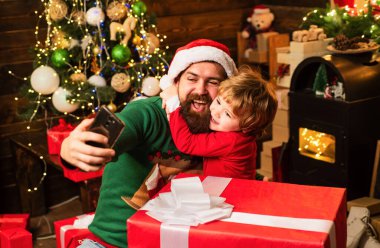 Noel Baba ve yaşlı sakallı Noel Baba akıllı telefon kullanıyor. Kış Noel heyecanı. İnternet, kablosuz ve sosyal medya kavramı