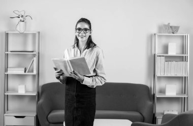 Ofisteki modern işyerinde çalışan çekici bir sekreter kadın. Not defteri ya da not defteri tutan güzel bir muhasebeci kız.