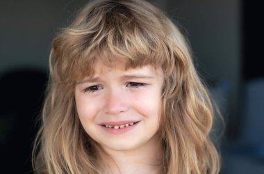 Yüzünde yaşlarla ağlayan çocuğu kapat. Yanağında yaşlarla ağlayan bir çocuk