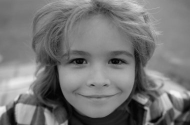 Komik çocukların açık havada çekilmiş hayat tarzı yakın plan portresi. Yazlık çocuk açık hava portresi. Şirin çocuğun yüzünü kapat. Çocuk güneşli bir yaz gününde dışarıda eğleniyor.