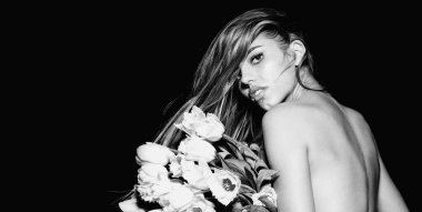 Sensual spring woman in studio, banner for website header. Girl with spring flowers. Beautiful naked young woman holding pink flower bouquet