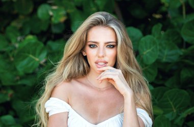 Baharın tadını çıkaran güzel bir kadın. Açık havada güzel bir genç kadın portresi. Temiz ciltli genç bir kızın yakın plan güzel yüzü. İlkbaharda romantik bir kız