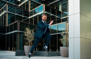 Businessman running in city is happy to succeed in his work. Business man winner