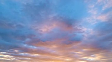 Güneş batıyor, bulutlar mavi ve turuncu dramatik gökyüzünde, güneş ışınlarıyla. Gece Gökyüzü zaman çizelgesi. Gün batımında hareket eden bulutlar. Akşam bulutları. Alacakaranlık gökyüzü zaman aşımına uğradı. Dramatik destansı akşam gökyüzü