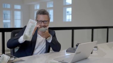 Ofiste parası olan bir iş adamı. Bir sürü banknot tutan bir iş adamının portresi. Dolar, kredi, internet bankacılığı. Zengin iş adamları dolar banknotları, banka kredileri