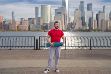 Spor salonundaki adam Manhattan yakınlarında egzersiz yapıyor. Sağlıklı egzersizler. Aktif kıdemli adam dışarıda fitness egzersizi yapıyor. Emeklilikten sonra egzersiz. Olgun emekli sporcu esneme egzersizleri yapıyor.