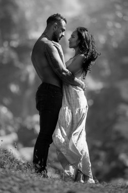 Romantik aşıklar. Birbirine aşık genç bir çift doğada sarılıyor. Flört ederken kucaklaşan harika bir çiftin portresi. Genç çift balayının tadını çıkarıyor. Sevgi dolu genç ve seksi bir çift.