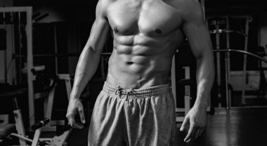 Spor salonundaki adam. Spor salonunda egzersiz yapan kaslı bir adam. Güçlü erkek, çıplak karın kasları.