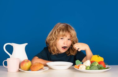 Çocuklar için sağlıklı bir kahvaltı. Küçük çocuk yemek yiyor. Aç surat, afiyet olsun sana, afiyet olsun. Çocuk çorba içiyor. Kaşıkla çorba içen genç çocuk