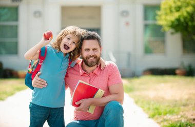 Okul bahçesinde mutlu bir aile. Okullu çocuk babamla aynı okula gidiyor.