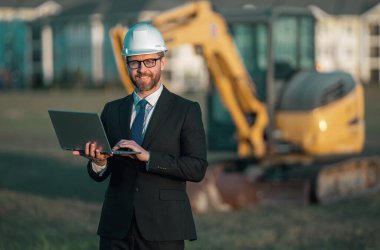 İnşaat mühendisi ya da inşaat mühendisi. İnşaat alanında kask ve takım elbiseli mühendis. Kazıcının yanındaki inşaat müdürü. Yenileme konsepti