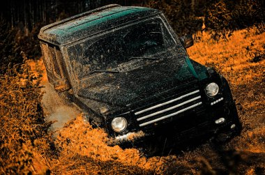 Sürüklenen yarış arabası lastik yakar. Dağ yolunda yol dışına. Çamurda iz sürmek. 4x4 Offroad SUV arabası. Gezgin off-road aracı. Safari. En iyi off road araçları. Çamur ve su off-road yarışında sıçrıyor