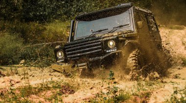 Off-road aracı dağa gidiyor. Alt manzaradan büyük off-road araba tekerine, şehir yolu ve dağ zemininde. Çamurlu bir arazide izler. Çamur, ıslak çamur veya kilden oluşan bir alanda off-road yapmaktır.