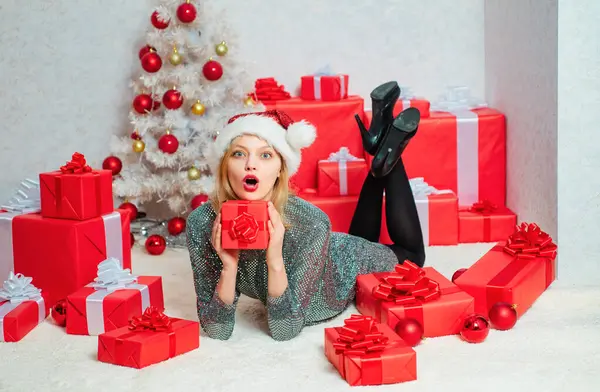 stock image Beauty Model Girl in Santa Hat on home design decorate. Euphoria. Cute young woman with santa hat. Funny girl in santa clause costume. Portrait of a young smiling woman