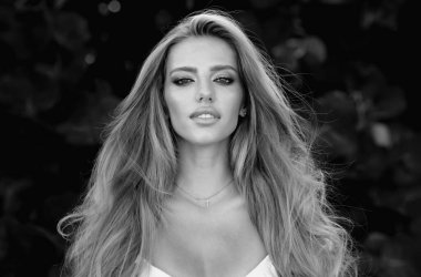 Güzel genç kız bahar parkında dinleniyor. Güzel bir kadının yakın portresi. Yaz parkında güzel bir genç kız. Yaz arkaplanındaki güzel kız modeli.