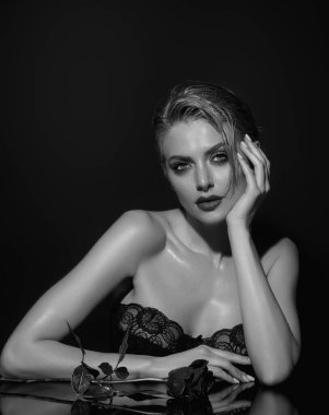 Seksi ve şehvetli bir manken. Romantik bir randevu ya da evlenme teklifi. Sıska, seksi, çıplak omuzlu, kırmızı güller tutan, stüdyo arka planında soyutlanmış bir kadın. Çiçekli şehvetli bir kızın portresi