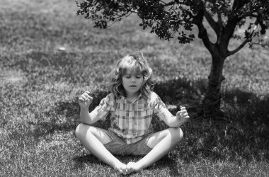 Sakinleş ve rahatla. Bilinçli meditasyon. Rahat çocuk, gözlerini doğaya kapamış. Yaz rüyası. Çocuk çimenlerde rüya görüyor. Çocukluk rüyası. Hayalperest çocuk. Hayaller ve hayal gücü. Rüya gibi çocuklar.