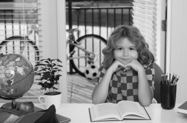 Çocuk kitabı okuyor. 7-8 yaşlarında, elinde kitap olan bir okul çocuğu okula geri döner. Biraz öğrenme ve ödev yapma. Ev kavramında eğitim