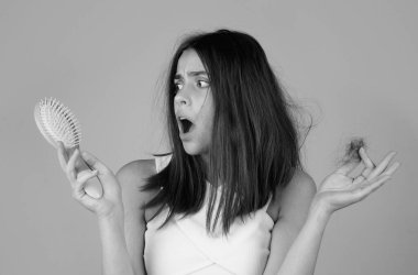 Saç dökülmesi sorunu olan üzgün bir kadın saç dökülmesinden endişeleniyor.