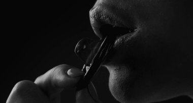 Kızlar kondom yalarlar. Aşktan önce ön sevişme. Kadın ağzı kapanış prezervatifi. Aşk, cinsellik ve güvenli seks konsepti. Prezervatifli şehvetli seks. Güvenli seks koruması seçimi. Prezervatifli oral seks.