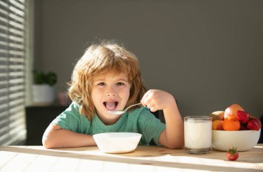 Çocuk evde sağlıklı yiyecekler yiyor. Bebek kaşıkla çorba içer