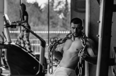 Fitness man in the gym. Young muscular man workout. Man with sexy strong body, strength and motivation. Fitness man at workout in gym pumping up muscles. Fitness and bodybuilding health