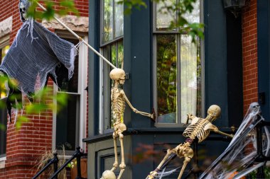 Cadılar Bayramı süslemeleri. Cadılar Bayramı balkabağı ve dekore edilmiş ev için iskelet. Bir Amerikan evinin ön bahçesinde dekore edilmiş korkunç bir şey. Şeker mi şaka mı? Cadılar Bayramı geçmişi. Cadılar Bayramı 'nın sonbahar tatili