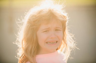 Closeup face of child boy crying outdoor. Kids cry. Unhappy sad kid face clipart