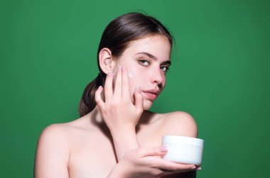 Kozmetik krem süren bir kadın. Yüzüne cilt bakımı yapan spa modeli. Sabah makyajı. Cilt kaldırma ve yaşlanma önleyici etki için nemlendirici cilt kremi, losyon veya maske