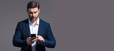 Takım elbiseli adam akıllı telefon kullanıyor. Portre çekici, neşeli adam telefonu kullanıyor, cep telefonundan arıyor. Akıllı telefon stüdyosu özgeçmişi olan yakışıklı bir adam. Banner, boşluğu kopyala