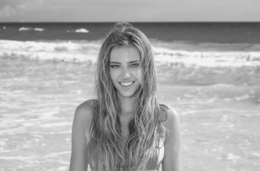 Woman in bikini on the tropical beach. Summer portrait of young beautiful girl on beach with bikini. Beautiful young woman on the beach. Freedom and carefree concept