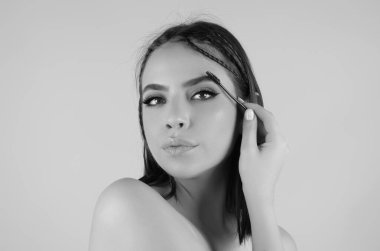 Beautiful woman with perfect shape eyebrows. Womans brows close up. Beautiful girl with eyebrow brush. Eyebrow correction. Long eyelashes and thick eyebrows