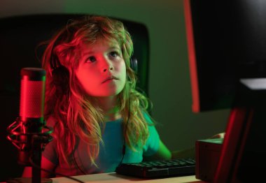 Geceleri bilgisayar kullanan bir çocuk. Aletlerin aşırı kullanımı ve bağımlılığı. Okul, eğitim, online öğrenme konsepti. Klavyede yazan öğrenci.