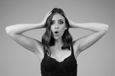 Girl raising eyebrows being surprised and shocked. Astonished reaction on unexpected news. Girl in t-shirt on isolated studio background with shocked, surprise and amazed expression on face
