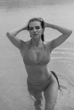 Beautiful young woman in a swimming pool, hot summer. Beautiful women relaxing at the luxury poolside. Female at travel spa resort pool. Summer luxury vacation