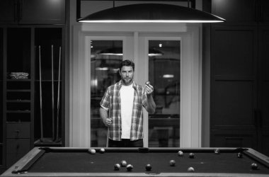 Bilardo oynayan adam. Bilardo salonunda topa vurmaya çalışan bir adam. Rus bilardosu. Bilardo oyuncusu. Siyah bilardo kulübünde bilardo oynayan genç bir profesyonel.